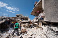 Workers dig through the rubble of KOTELAM, a credit union in Port-au-Prince.