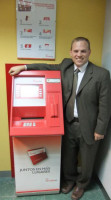 Steve Schaefer a lado del cajero automático en la Cooperativa de Ahorro y Crédito Santa María Magdalena.