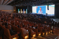 General session attendees watch a video interview with Tom Neylan